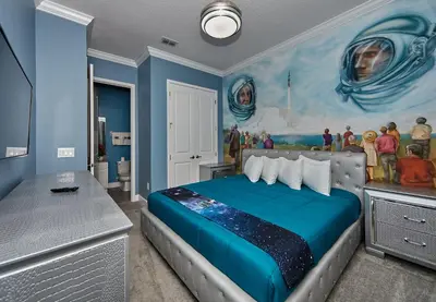 a bedroom with a bed with a painting on the wall at Remarkable Mansion Sleep 36 Cinema-Bowling Alley & More in Kissimmee