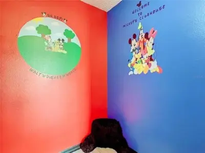 a corner of a room with a wall with a mickey mouse mural at Disney Themed Condo in Kissimmee