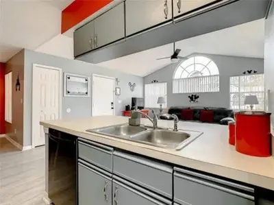 a kitchen with a sink and a living room at Disney Themed Condo in Kissimmee