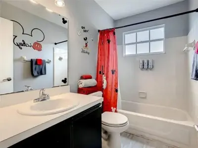 a bathroom with a sink and a toilet and a tub at Disney Themed Condo in Kissimmee