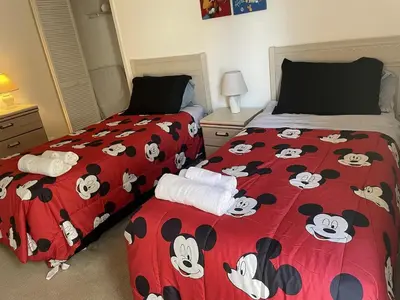 a bedroom with two beds with mickey mouse comforter at 2974 Viscount Villa 3bed Pool in Kissimmee