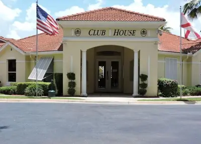 a club house with two flags in front of it at 1061 Lake Berkley 4 Bed with Pool in Kissimmee