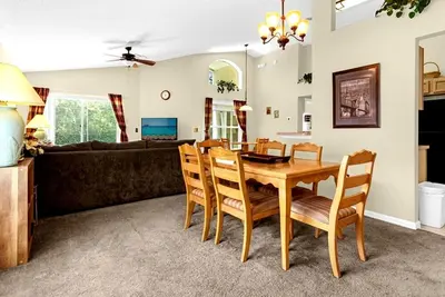 a dining room and living room with a table and chairs at 1061 Lake Berkley 4 Bed with Pool in Kissimmee