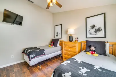 a bedroom with two beds and a tv at 11 Mi to WDW Kissimmee House with Private Pool! in Kissimmee
