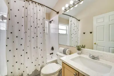 a bathroom with a shower curtain and a toilet and a sink at 11 Mi to WDW Kissimmee House with Private Pool! in Kissimmee
