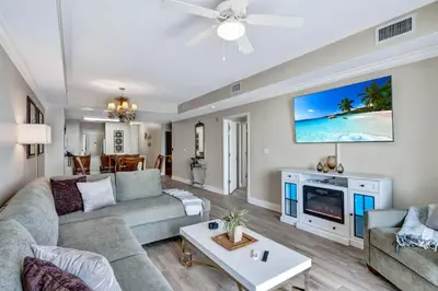 a living room with a couch and a tv at Sunshine Oasis - Orlando Lakefront Luxury in Orlando