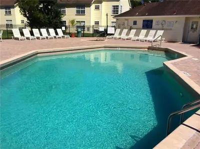 a large blue swimming pool with chairs in a yard at HARRY POTTER LIVES HERE! Unforgettable Home, Pool, Sleeps 8, Near Dis, LOW Rates! in Kissimmee