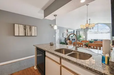 a kitchen with a sink and a living room at FABULOUS New Decor, Near Dis, Fireplace, Star Wars Children's BR, Next To Pool, LOW rates! in Kissimmee