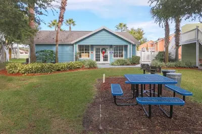 a picnic table and chairs in front of a house at FABULOUS New Decor, Near Dis, Fireplace, Star Wars Children's BR, Next To Pool, LOW rates! in Kissimmee