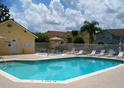 a swimming pool with chairs and a fence at FABULOUS New Decor, Near Dis, Fireplace, Star Wars Children's BR, Next To Pool, LOW rates! in Kissimmee