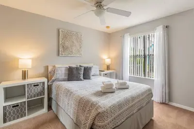 a bedroom with a large bed and a window at SPECTACULAR, NEW Professional Decor, Near Dis, NO Steps, Pool, Patio, LOW Rates! in Kissimmee
