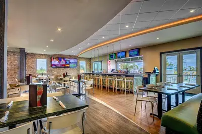 a restaurant with tables and chairs and a bar at Spacious Home With Private Pool Near Disney With Waterpark & Resort Access At Encore Resort - 7720Ff in Kissimmee