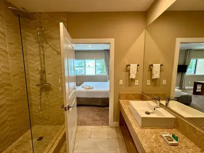 a bathroom with a sink and a shower and a bed at Luxury Home in Orlando with private Hot Tub - 7 Min from Disney Parks - 3 bedrooms and 4 bathrooms! in Orlando