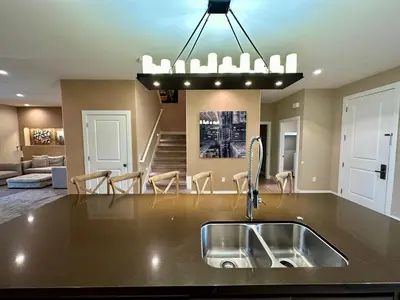 a kitchen with a sink and a living room at Luxury Home in Orlando with private Hot Tub - 7 Min from Disney Parks - 3 bedrooms and 4 bathrooms! in Orlando