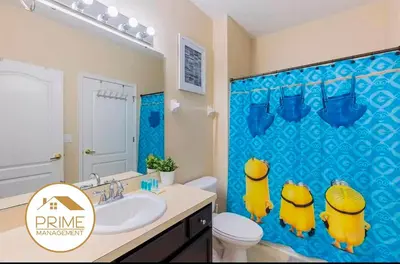 a bathroom with a blue shower curtain with yellow ducks at Cozy 4bdhome By Lake Prime Location Disney in Kissimmee