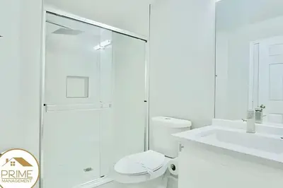 a bathroom with a shower and a toilet and a sink at Renewed & Cozy 4BD Great Location near Disney in Kissimmee