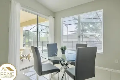 a dining room with a glass table and chairs at Renewed & Cozy 4BD Great Location near Disney in Kissimmee