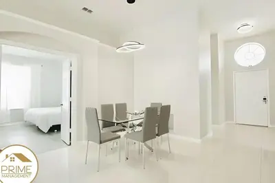 a dining room with a table and chairs and a bed at Renewed & Cozy 4BD Great Location near Disney in Kissimmee