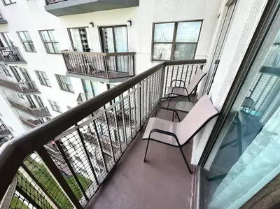a balcony with two chairs and a building at Cozy Getaway in Orlando
