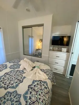 a bedroom with a bed with a mirror and a dresser at The Hidden Gem Cottage in Kissimmee