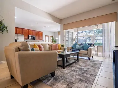 a living room with a couch and a table at Luxury Disney Villa 5BR With Private Pool and Spa (4 Miles from Disney) in Orlando