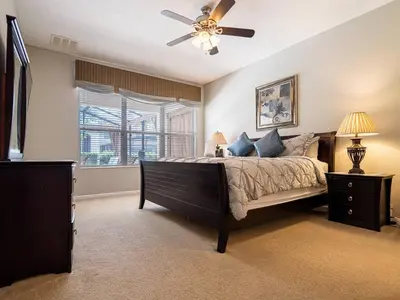 a bedroom with a bed and a ceiling fan at Luxury Disney Villa 5BR With Private Pool and Spa (4 Miles from Disney) in Orlando