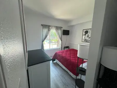 a small bedroom with a red bed and a window at 3 beds DisneyFree Shuttle in Orlando