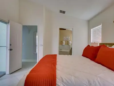a bedroom with a large bed with red sheets at Pool home 5 miles to Disney Great for families in Orlando