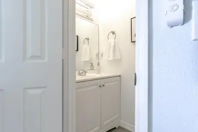a white bathroom with a sink and a mirror at Charming Lakeview Retreat I in Orlando