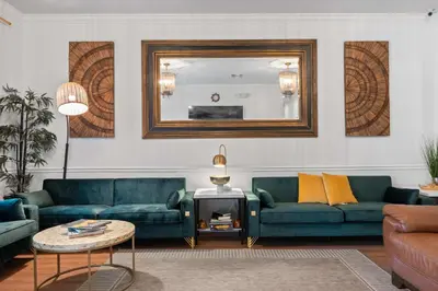 a living room with two blue couches and a mirror at Banana Leaf Villa-Island Groove-Standard Suite in Orlando