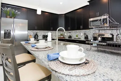 a kitchen with a counter with dishes on it at Perfect Disney Getaway House 6BR5BA • Private Pool at Storey Lake Resort SL4788 in Kissimmee