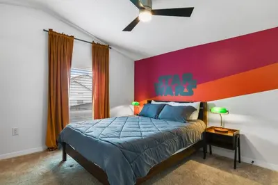 a bedroom with a bed with a colorful wall at Attention Star Wars fans Amazing 6 BR pool in Kissimmee