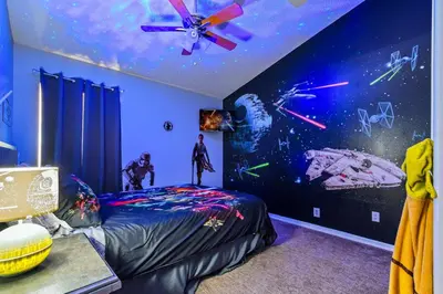 a room with a star wars bedroom with a ceiling fan at Wheelchair accessible Lakeview 4BR house with pool spa themed rooms game room in Kissimmee