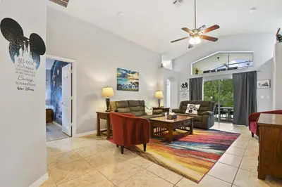 a living room with a couch and a table at Themed 4BR house pool game room 10 min Disney in Orlando