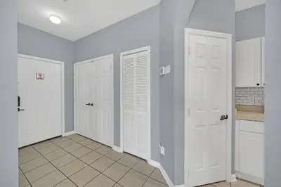 a kitchen with white doors and a tile floor at Star Wars Themed Home at Windsor Palms in Kissimmee