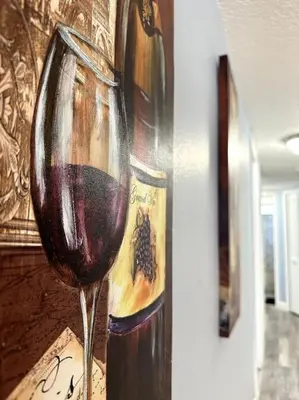a glass of red wine in front of a painting at Disney's Townhome in Kissimmee