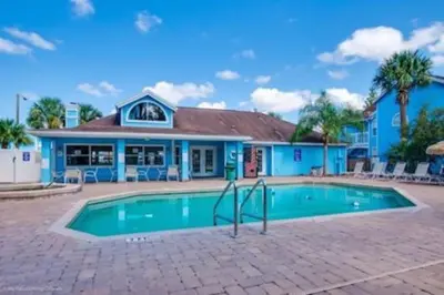 a swimming pool in front of a blue building at Disney's Townhome in Kissimmee