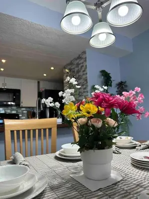 a table with a vase of flowers on top of it at Disney's Townhome in Kissimmee