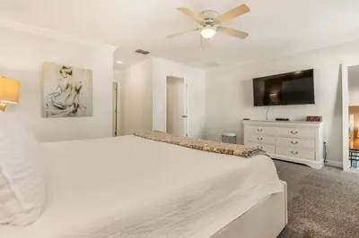 a white bedroom with a bed and a ceiling fan at Dream Getaway Modern 6-Bedroom Vacation Home in Kissimmee