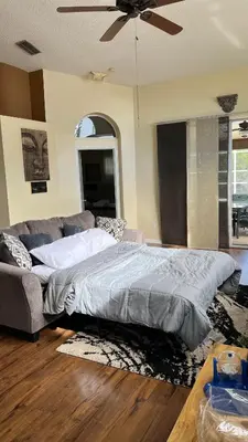 a bedroom with a large bed and a couch at Excelente Casa Vacacional in Kissimmee