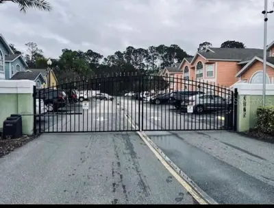 a black gate with cars parked in a parking lot at Disney enchantment getaway in Kissimmee