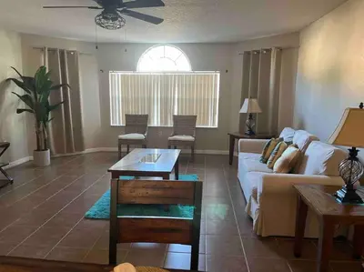 a living room with a couch and a table at Disney enchantment getaway in Kissimmee