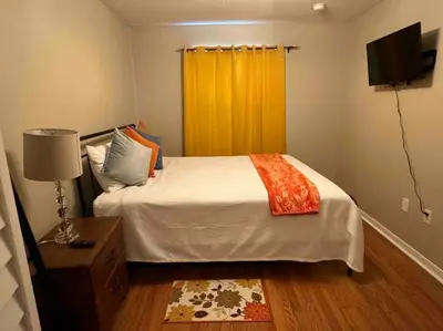 a bedroom with a bed and a yellow curtain at Disney enchantment getaway in Kissimmee