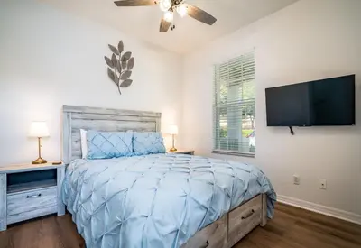 a bedroom with a bed and a flat screen tv at Disney Retreat Lakeview townhome - close to golf in Orlando