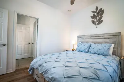 a bedroom with a large bed with a blue comforter at Disney Retreat Lakeview townhome - close to golf in Orlando