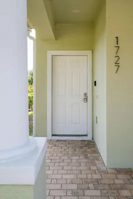 a white door in a room with a brick floor at Disney Retreat Lakeview townhome - close to golf in Orlando