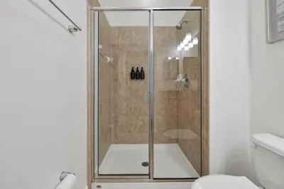 a shower with a glass door in a bathroom at Trendy Retreat - Great Location - Fully Loaded in Kissimmee