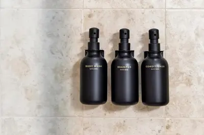 two black bottles sitting on a tiled floor at Trendy Retreat - Great Location - Fully Loaded in Kissimmee