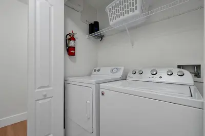 a white laundry room with a washer and dryer at Trendy Retreat - Great Location - Fully Loaded in Kissimmee