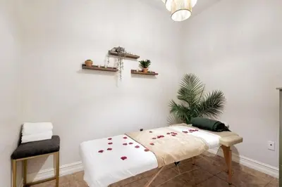 a white room with a bed and a chair at Banana Leaf Villa-Marley Junior Suite in Orlando